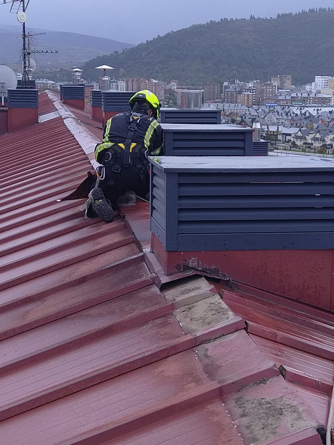 Los bomberos de Ponferrada retiran chapas sueltas en la cubierta de un edificio en la calle Matias Prats. / Ayuntamiento de Ponferrada