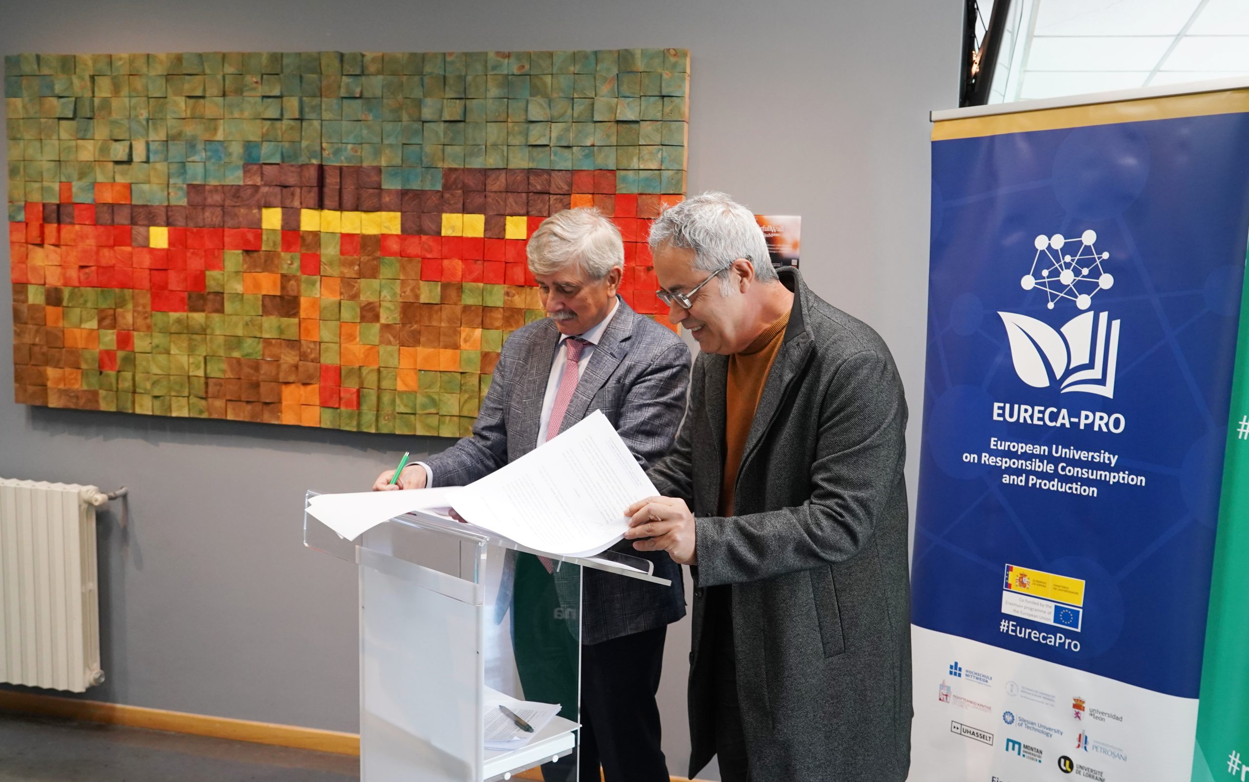 El rector de la ULE, Juan Francisco García Marín (I), durante la presentación del cuadro 'The Colorfull Wall', donado al Campus de Ponferrada por el artista y profesor Alfonso Fernández Manso (D)