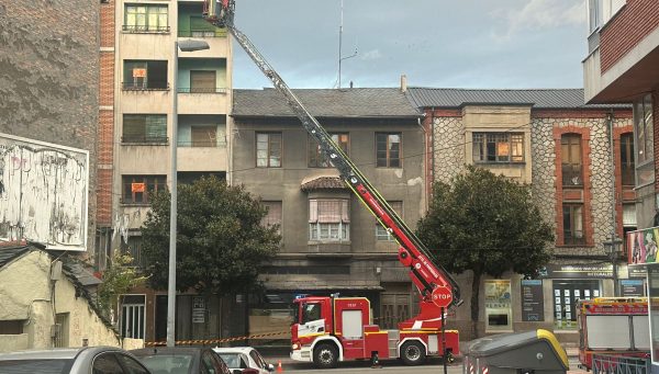 Los bomberos trabajan en la retirada de cascotes de un edificio de la avenida de la Puebla