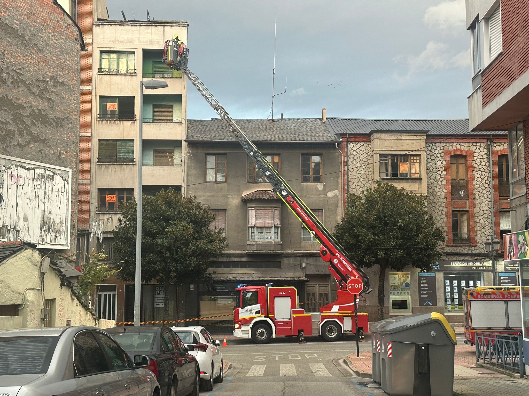 Los bomberos trabajan en la retirada de cascotes de un edificio de la avenida de la Puebla