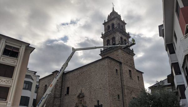 Operarios colocan las luces de Navidad en la torre de la Encina