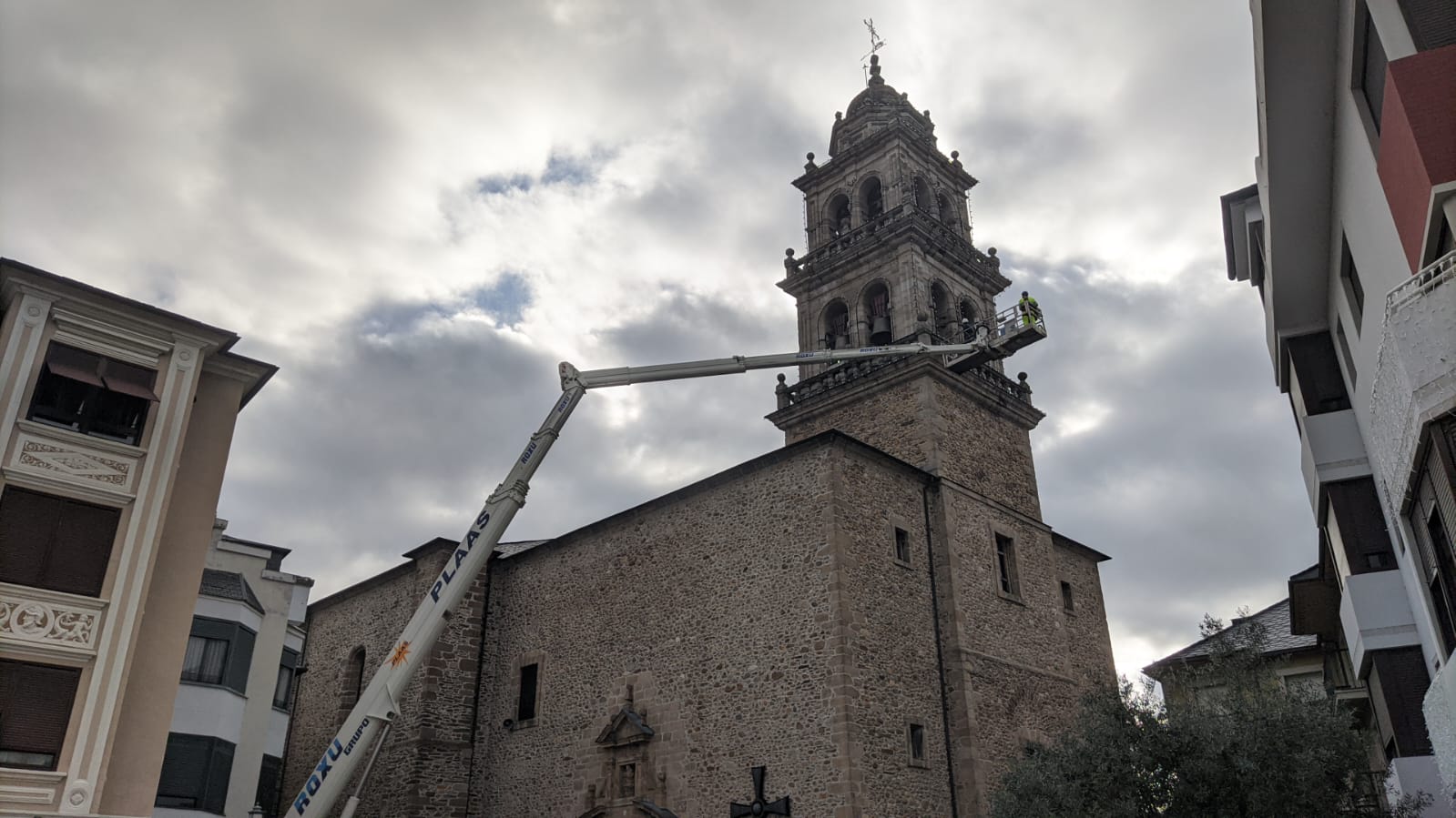 Operarios colocan las luces de Navidad en la torre de la Encina