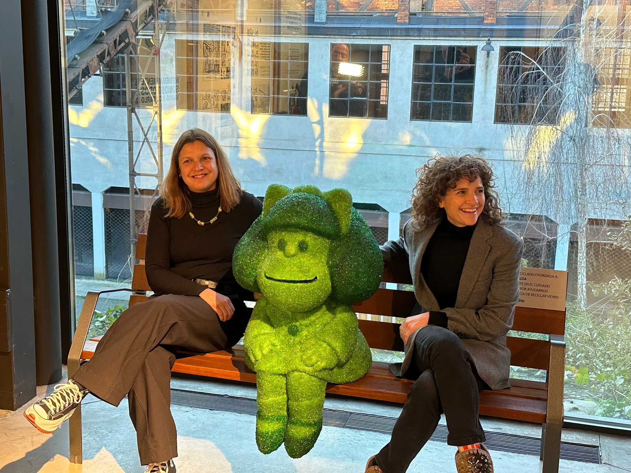 Yasodhara López y Concepción Fernández posan con la escultura de Mafalda en el Museo de la Energía.